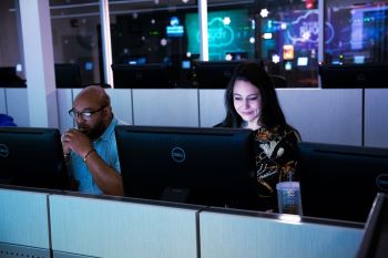 A group of people working at computers

Description automatically generated